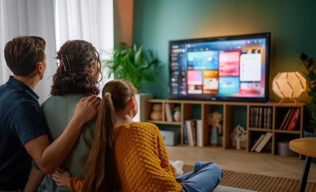 Family relaxing together watching their repaired Smart TV at home in Gauteng